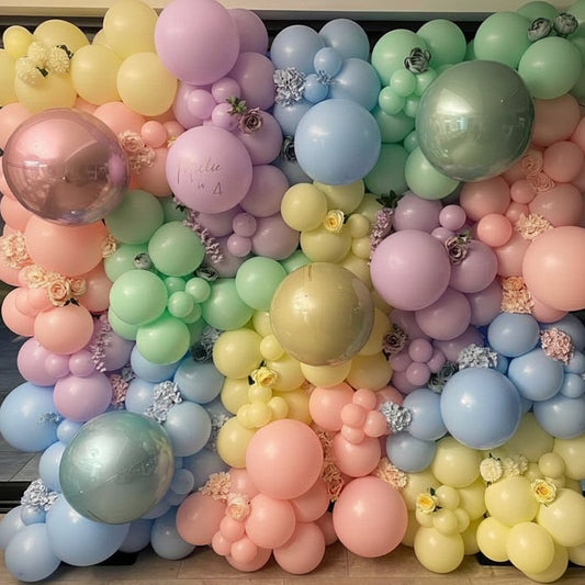 Pared de globos multicolores con flores y personalización