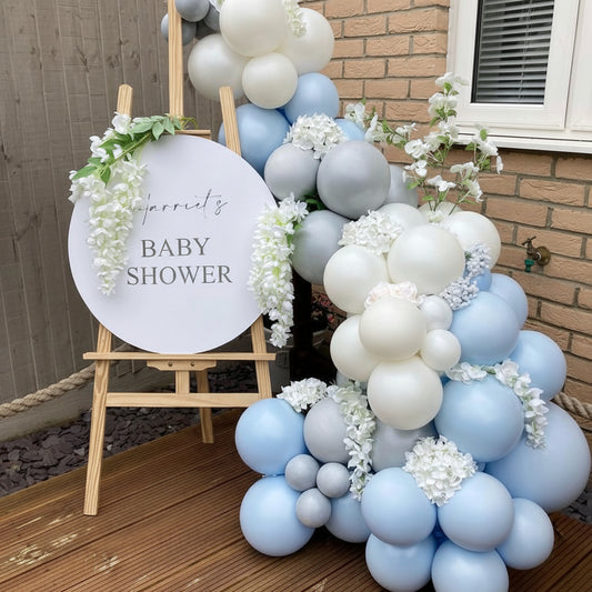 Panel de bienvenida con flores y globos azules y blancos