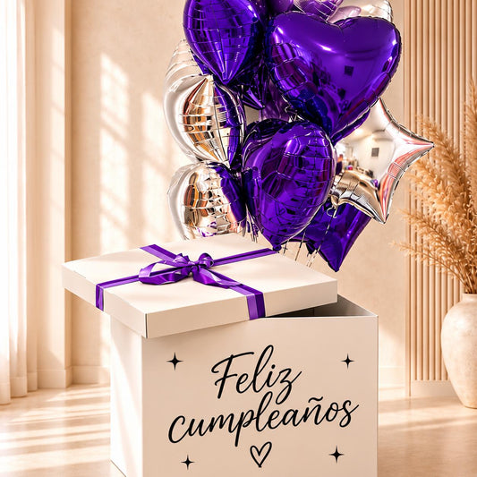 Detalle de la caja de cumpleaños con lazo morado y globos de foil morados y plateados.