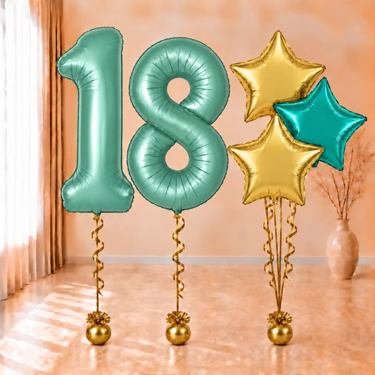 Composición de globos con números 18 turquesa, estrellas doradas y turquesa, cintas y contrapesos dorados.